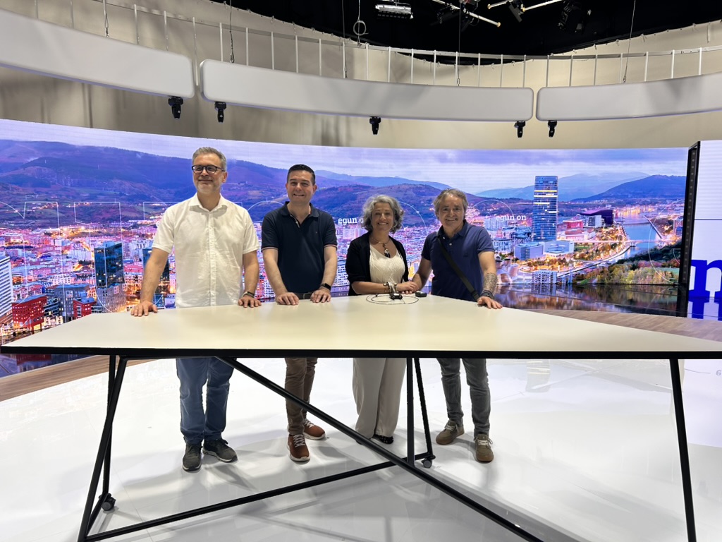 Grupo de quatro pessoas num estúdio de televisão, com uma vista de Bilbau no cenário.